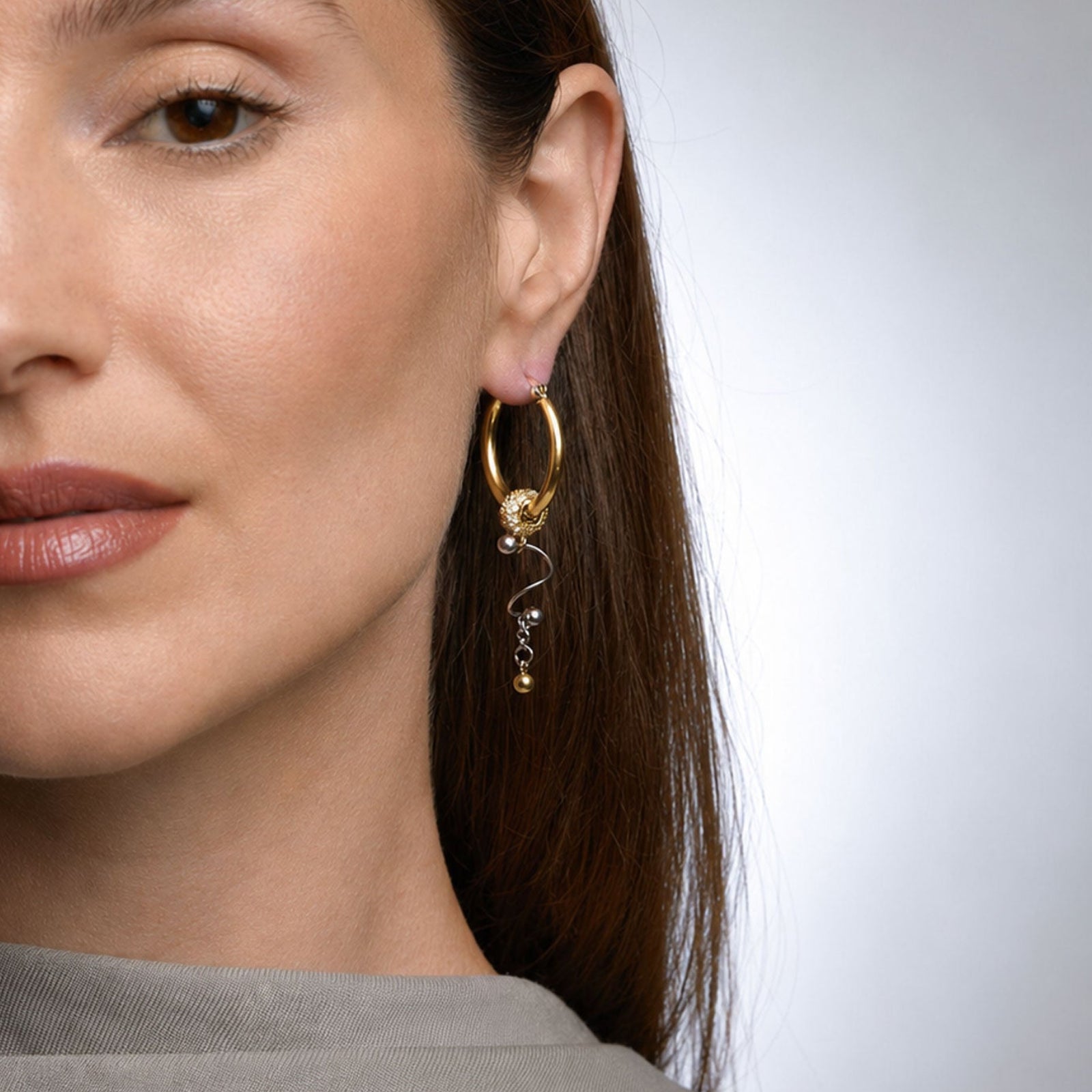 Modelo con pendientes de aro asimétricos BEND GOLD de Kirei Jewellery