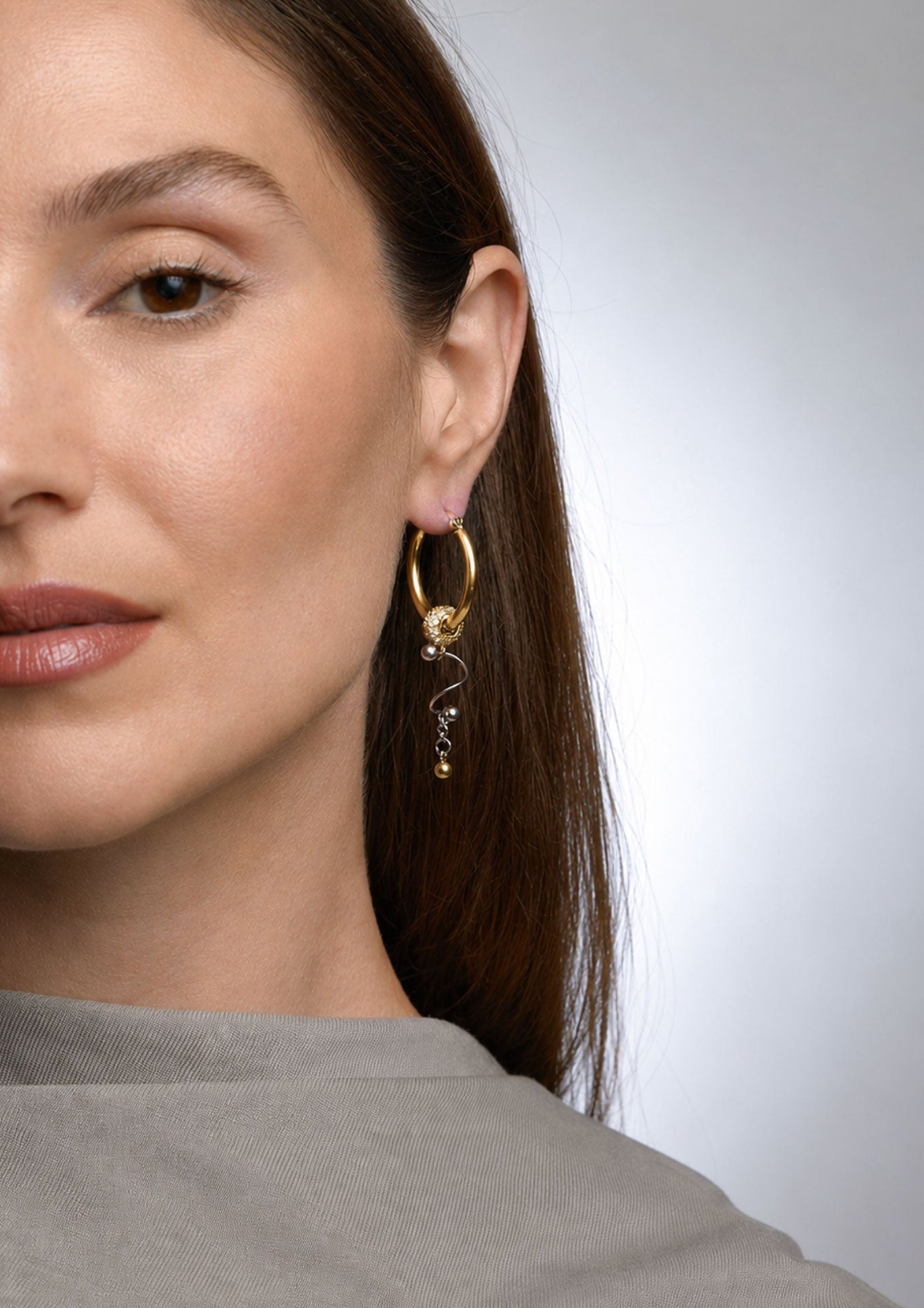 Modelo con pendientes de aro asimétricos BEND GOLD de Kirei Jewellery